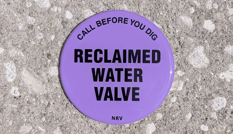 Purple reclaimed water valve warning sign.